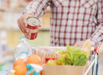 putting a canned good in a shopping cart